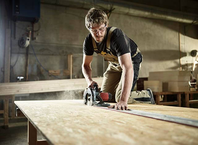 Furniture manufacturer using tools to cut wood