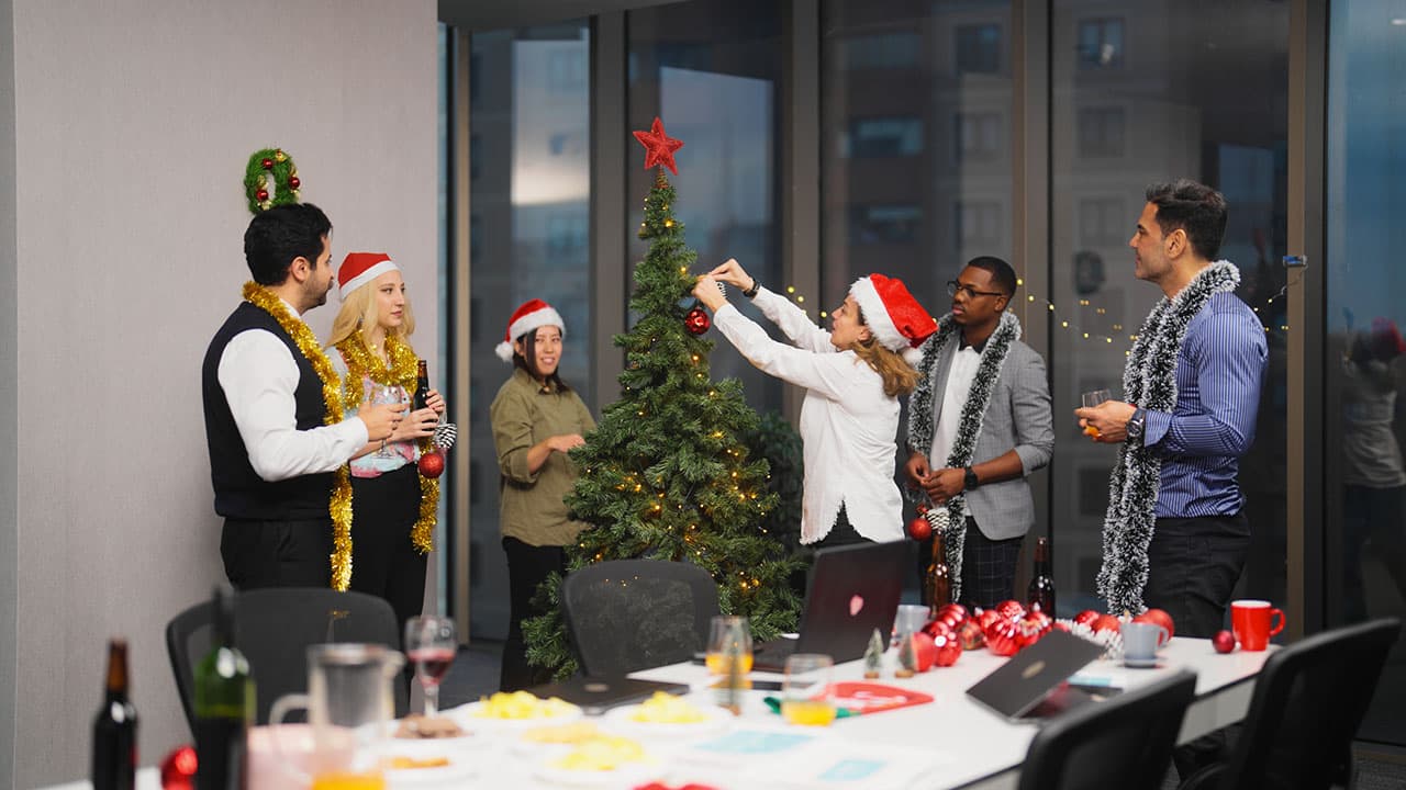Office workers decorating a christmas tree together