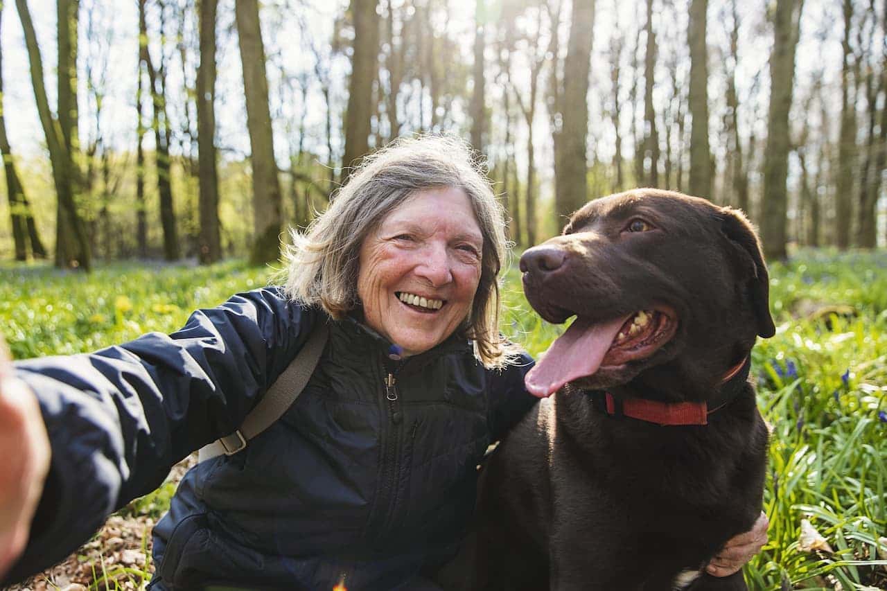 Lady smiling for a photo with her dog