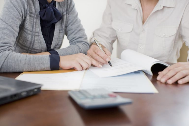 Business owners writing in their accounts book