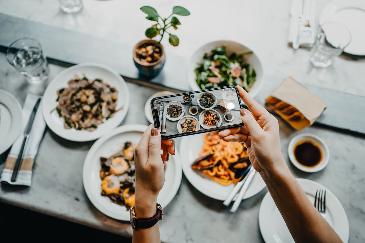 Blogger taking photos of their food in a restaurant