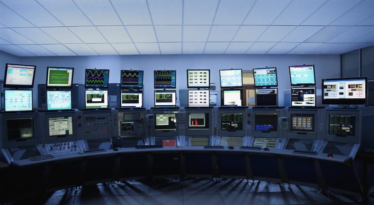 Busy control room with lots of computer screens