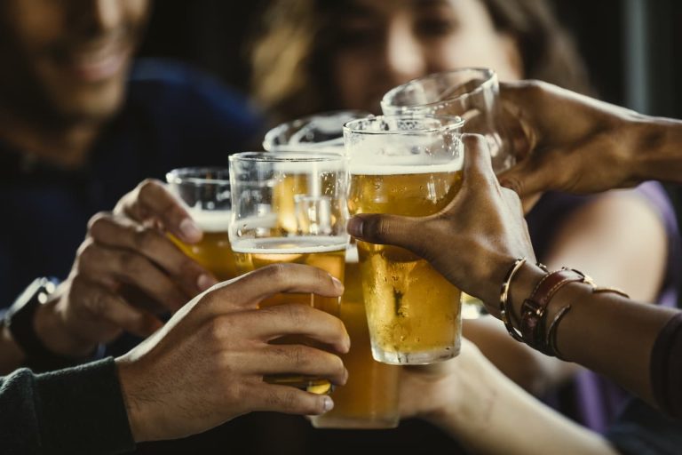 Pints of beer being held up in a toast
