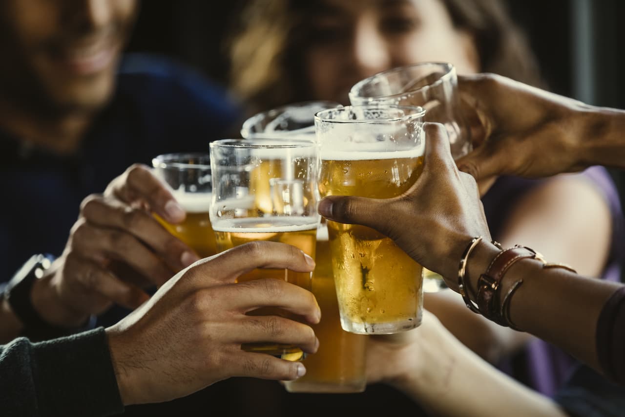 Pints of beer being held up in a toast