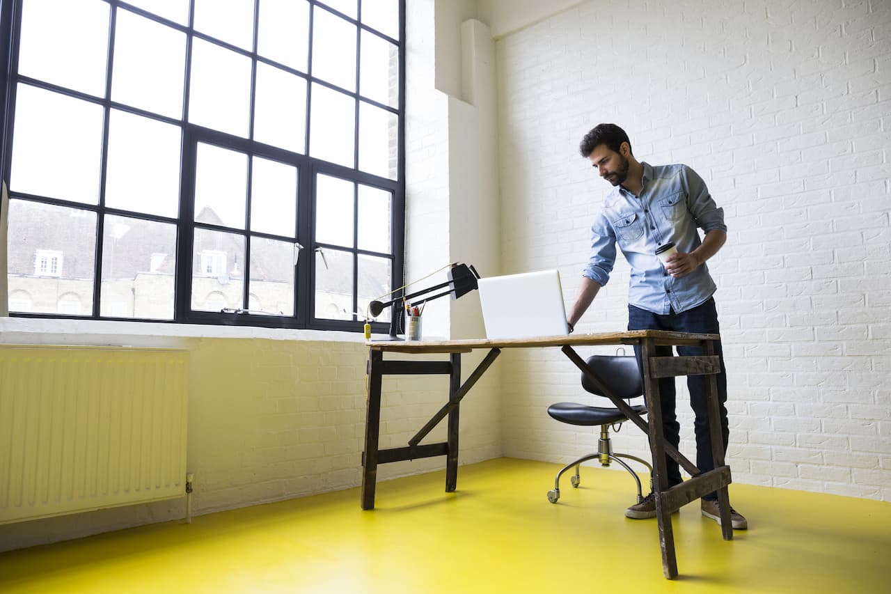 Person setting up a new desk next to a large window