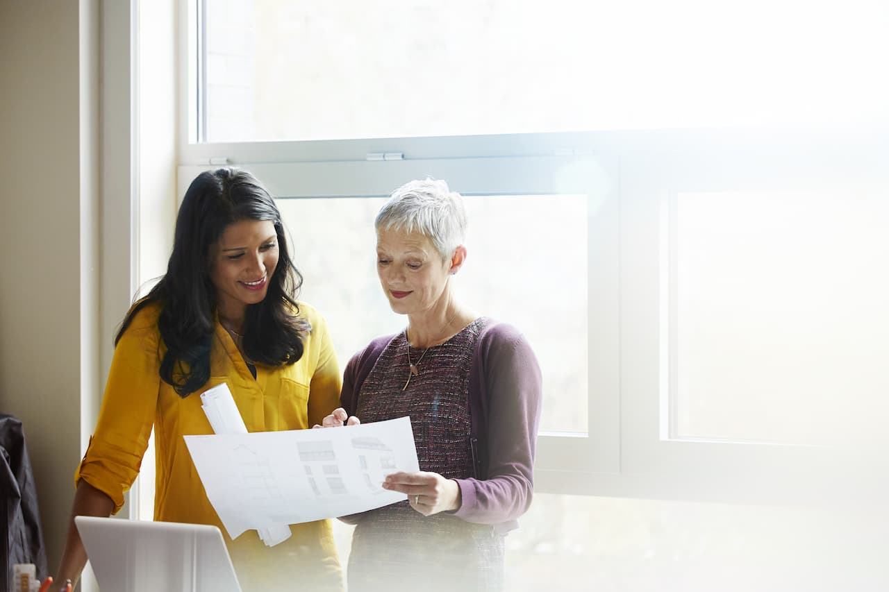 Two people discussing business documents