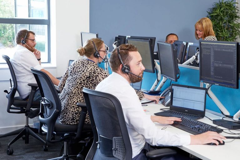 Insurance experts at Premierline sat at a bank of desks wearing telephone headsets.