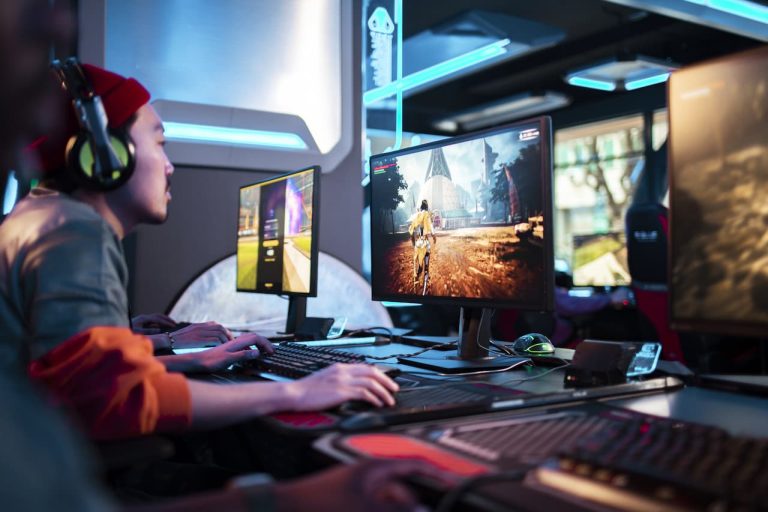 Person playing games on a PC with dual monitors