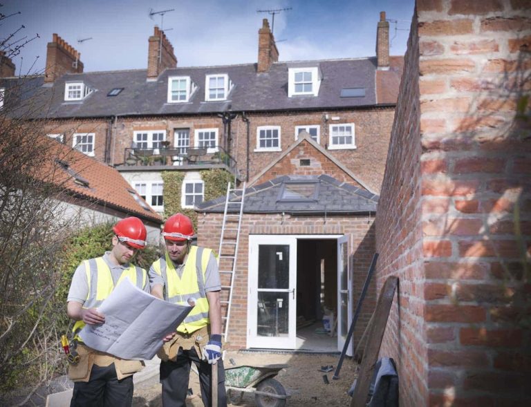Contractors looking at drawings in a garden