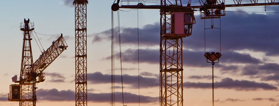 Construction cranes skyline at sunset
