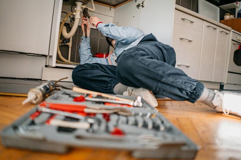 Plumber working under a sink