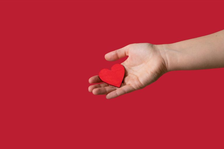 Open hand holding a paper love heart