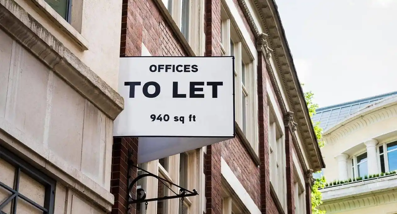 A building displays a sign stating "Offices to Let," suggesting available office rental opportunities.
