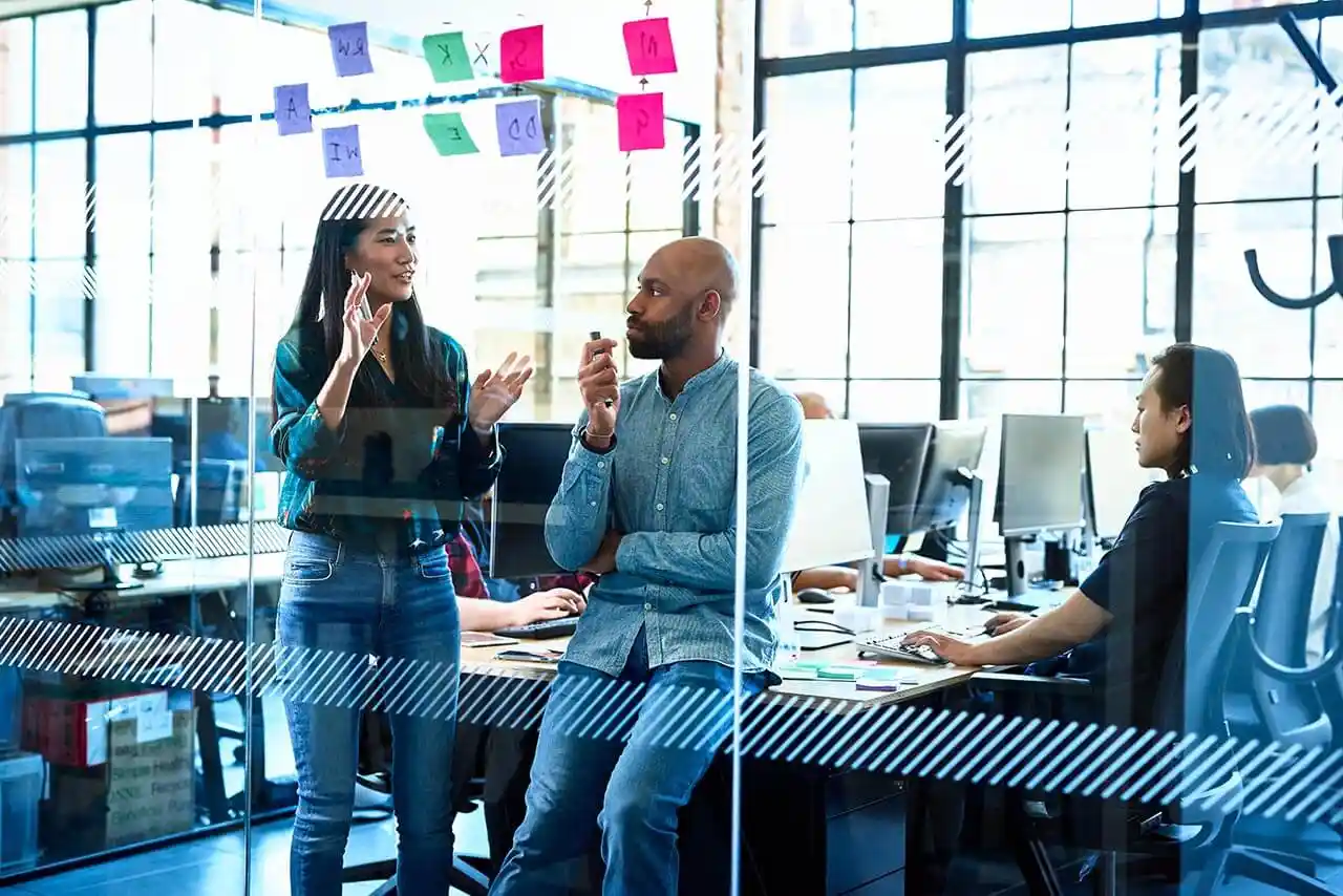 Two professionals meeting in an open plan office