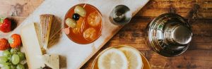 Close up of a cocktail shaker and a cheese board