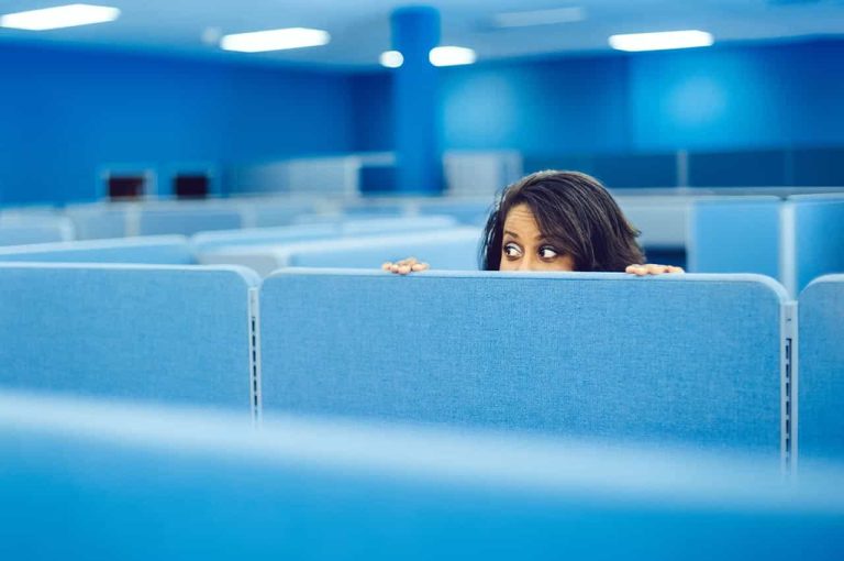Person looking over an office cubicle