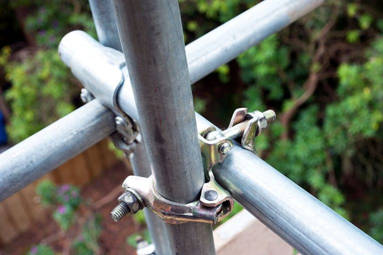 Close-up of a scaffolding metal pole and clamp for construction use.