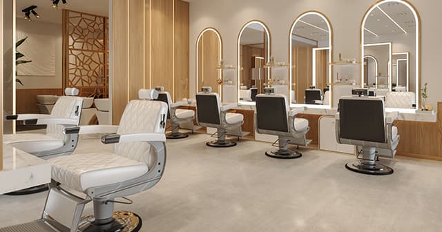 An elegant salon with white chairs and mirrors, providing a professional environment for hairdressers and barbers