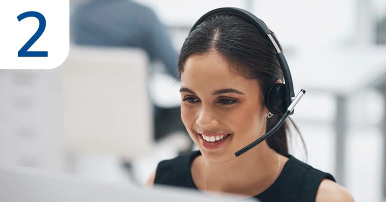 An insurance advisor in an office, wearing a headset and focused on her work while speaking with a client.