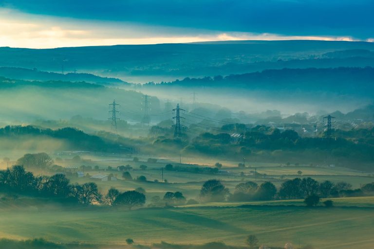 A scenic view of a valley filled with trees and rolling hills, showcasing the beauty of nature and energy efficiency