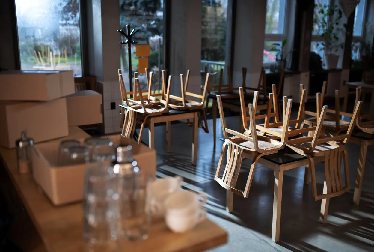 A room filled with chairs and tables, now empty, reflecting the closure of the business.