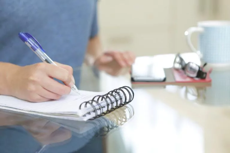 Person writing notes on a notepad