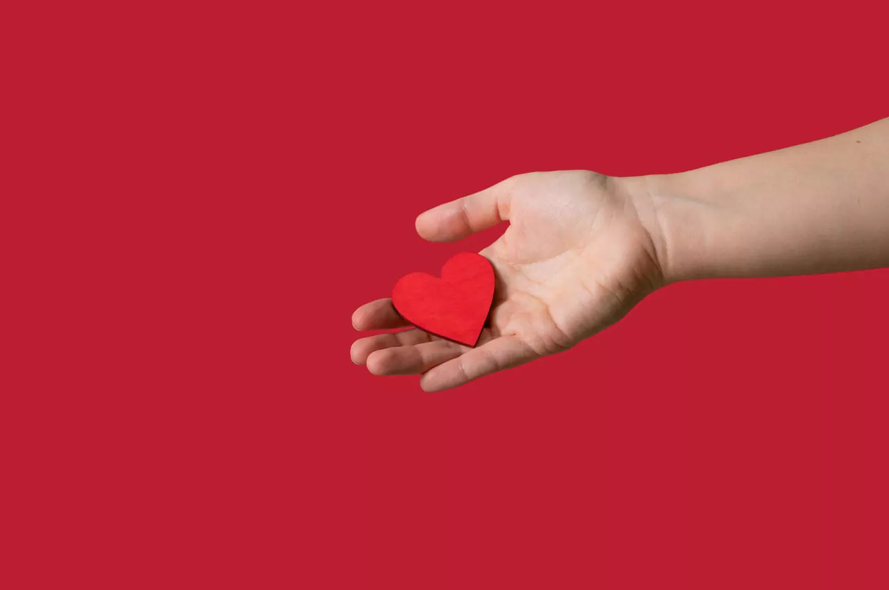 Open hand holding a paper love heart