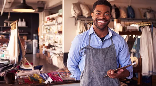 Employee in a retail gift shop, surrounded by textiles and home goods.