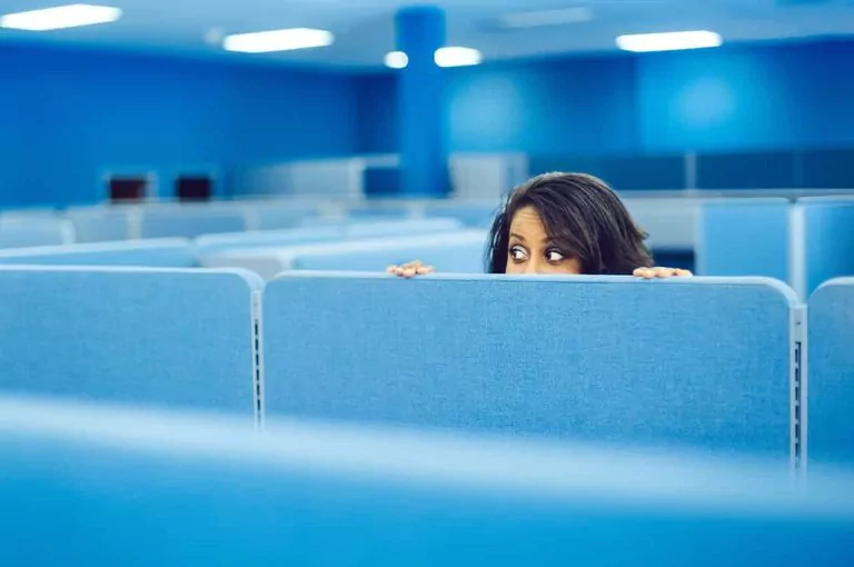 Person looking over an office cubicle